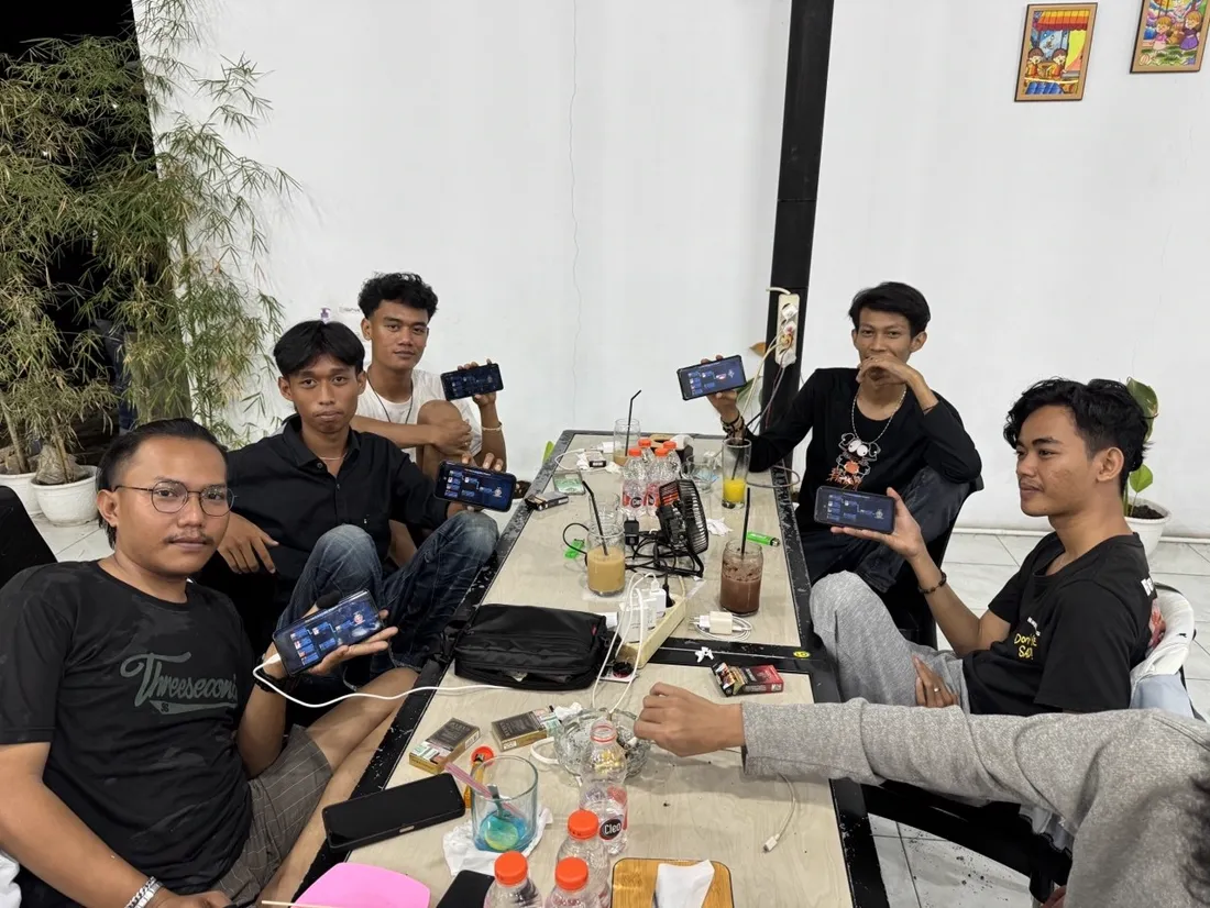 Sekelompok anak muda main game di HP bareng di meja Jaikopi