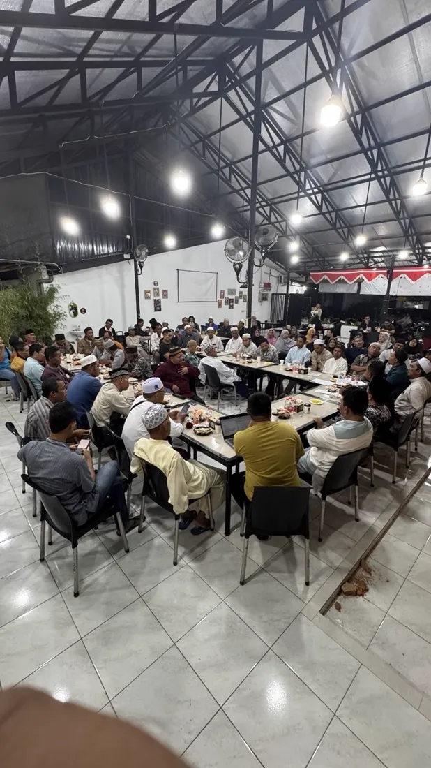 Jamaah pengajian duduk di meja panjang Jaikopi pada malam hari