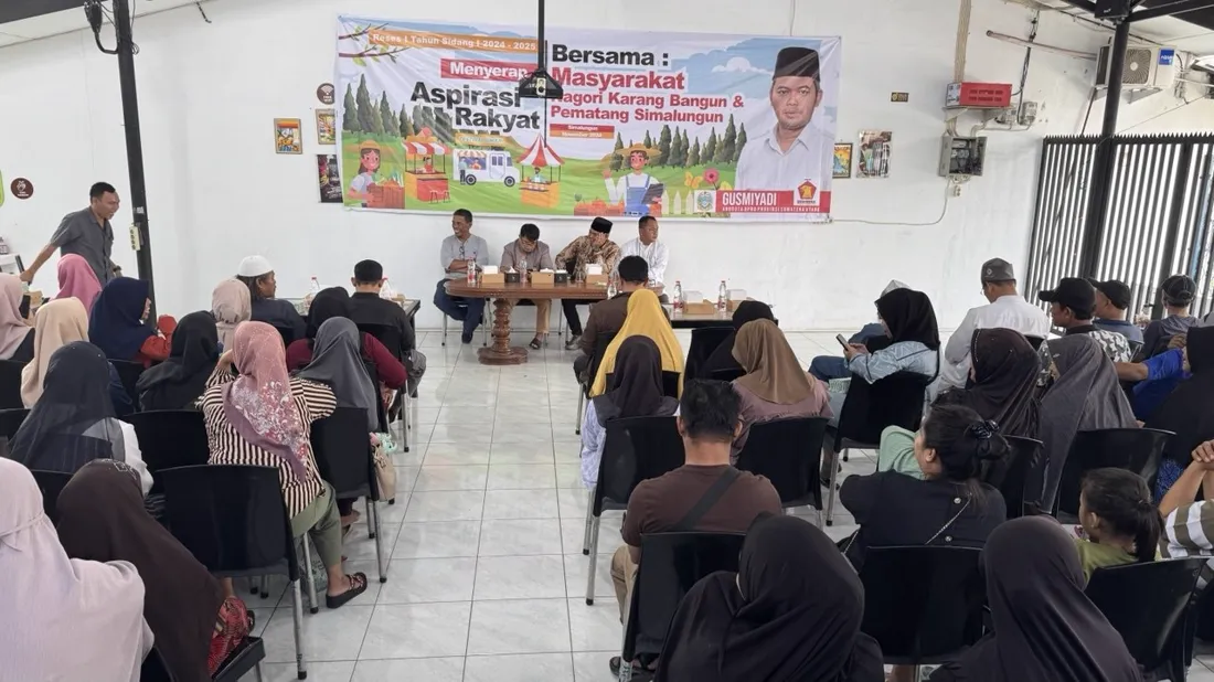 Pertemuan warga Nagori Karang Bangun dengan panel narasumber di depan dan warga duduk di kursi, di dalam Jaikopi