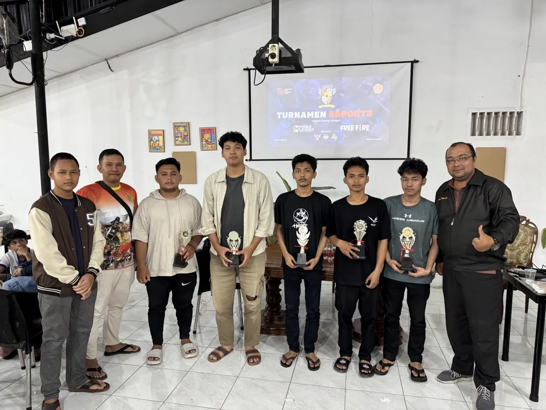 Para juara turnamen esports Nagori Karang Bangun memegang piala di Jaikopi